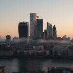 Aerial view of the City of London cluster at first light, the Walkie Talkie and Cheesegrater backlit through low river mist